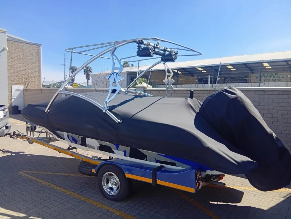 Wakeboard boat cover tailored around the tower, on its trailer